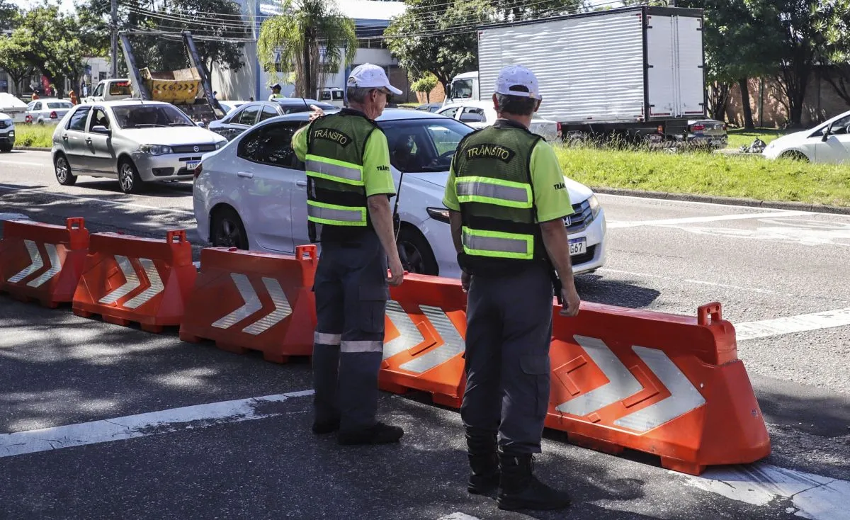Na imagem, agentes orientam o trânsito em bloqueio em rua de Curitiba