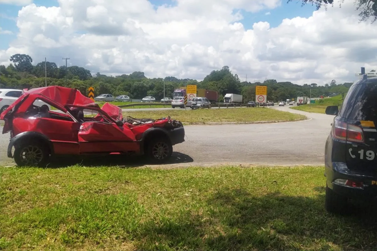 Na imagem, carro vermelho destruído após acidente envolvendo caminhões