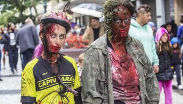 Imagem mostra pessoas fantasiadas de zumbi, parte da programação do Carnaval de Curitiba 2025