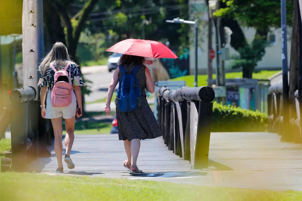 Imagem mostra duas mulheres andando em um dia de calor excessivo em Curitiba.