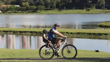 Pai e filho pedalam no Parque Barigui, em Curitiba