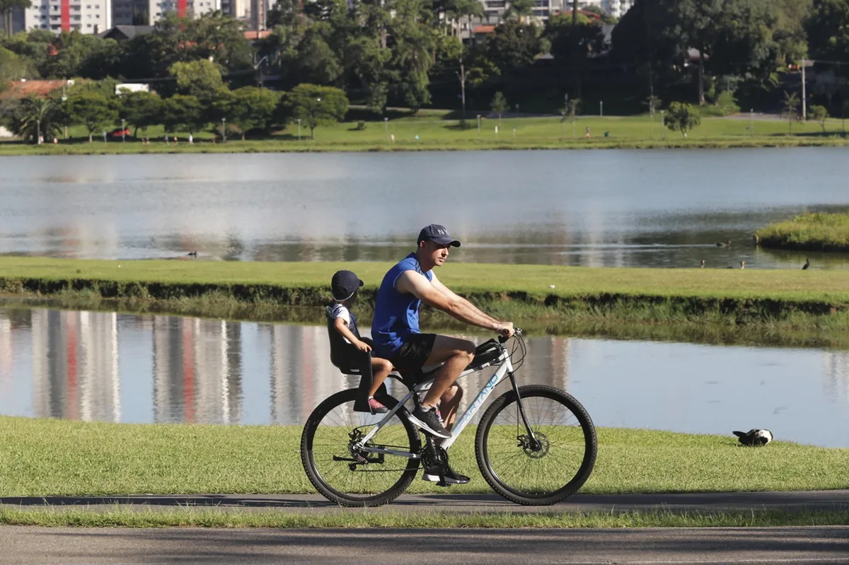 Pai e filho pedalam no Parque Barigui, em Curitiba