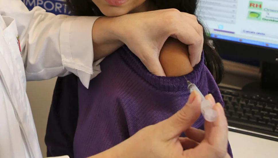 Imagem mostra menina recebendo vacina