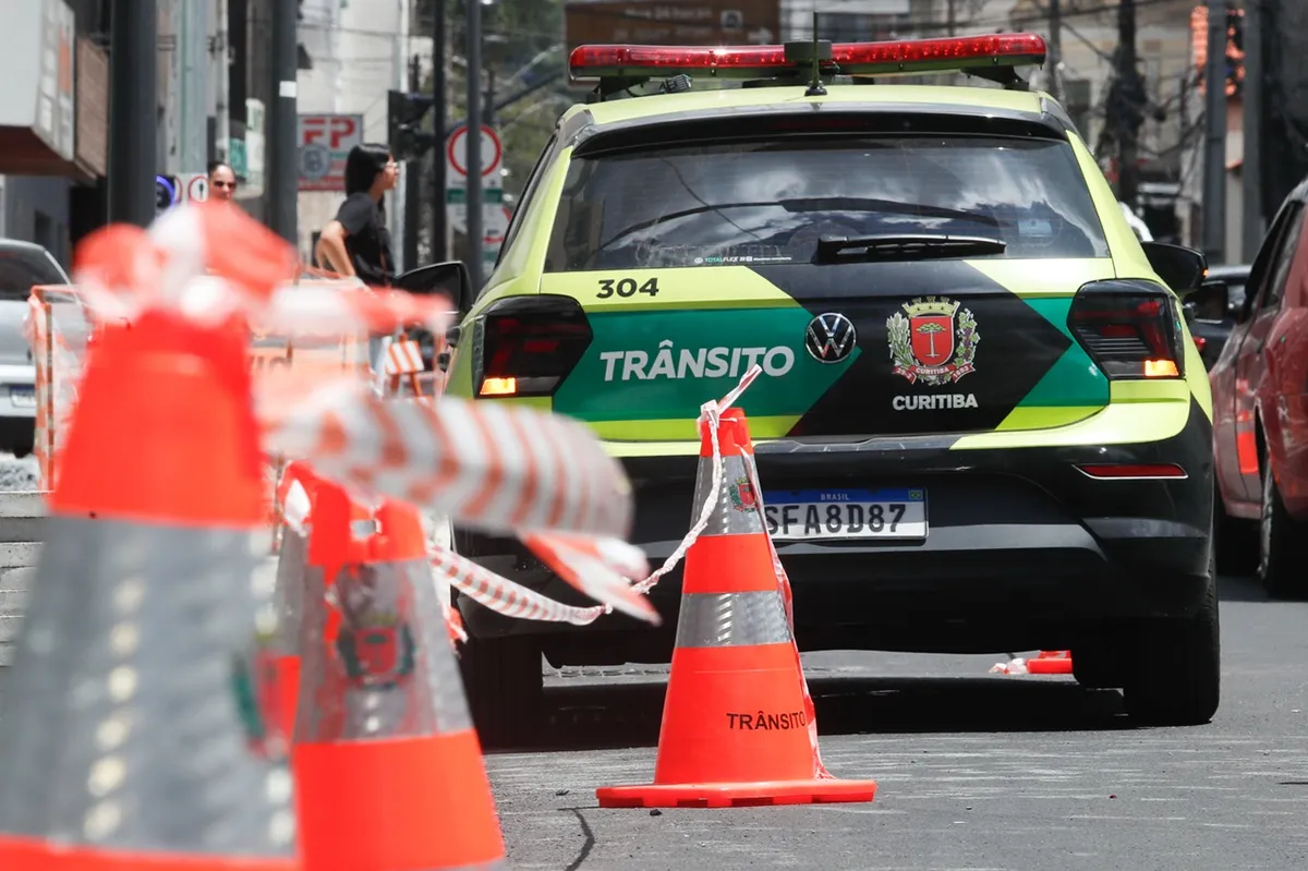Imagem mostra viatura da Setran e cones de bloqueio de trânsito, em Curitiba