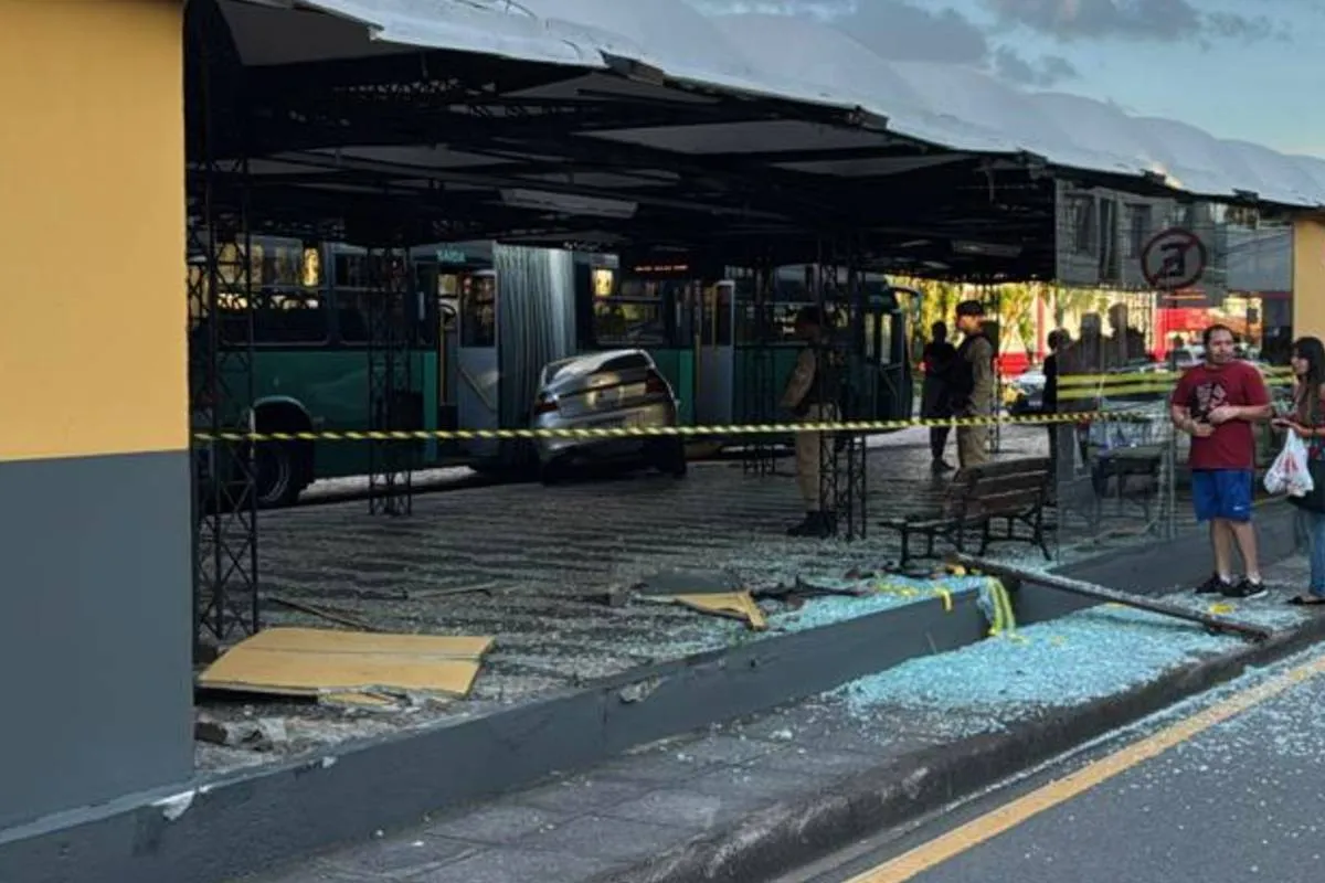 Imagem mostra um carro prata batido dentro de um terminal de Curitiba.