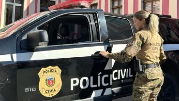 Imagem mostra policial civil entrando em viatura
