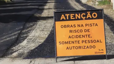 Imagem mostra placa de obras em rua de Curitiba