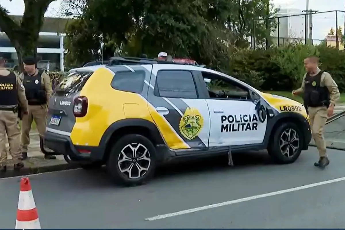 Imagem mostra uma viatura da PM sendo rebocada por um guincho e policiais no entorno dela.