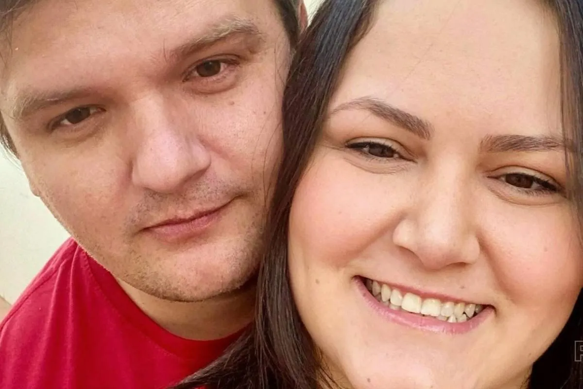 Imagem mostra um casal abraçado sorrindo para a foto.