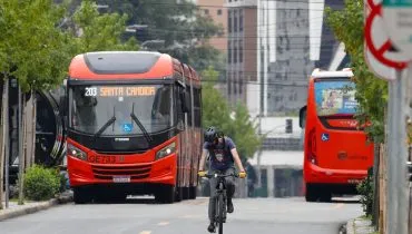 Ônibus em Curitiba circulando em canaleta exclusiva e ciclista