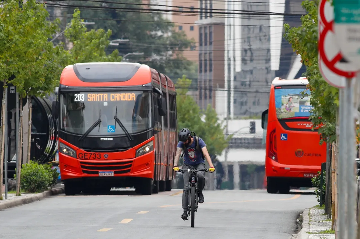 Ônibus em Curitiba circulando em canaleta exclusiva e ciclista