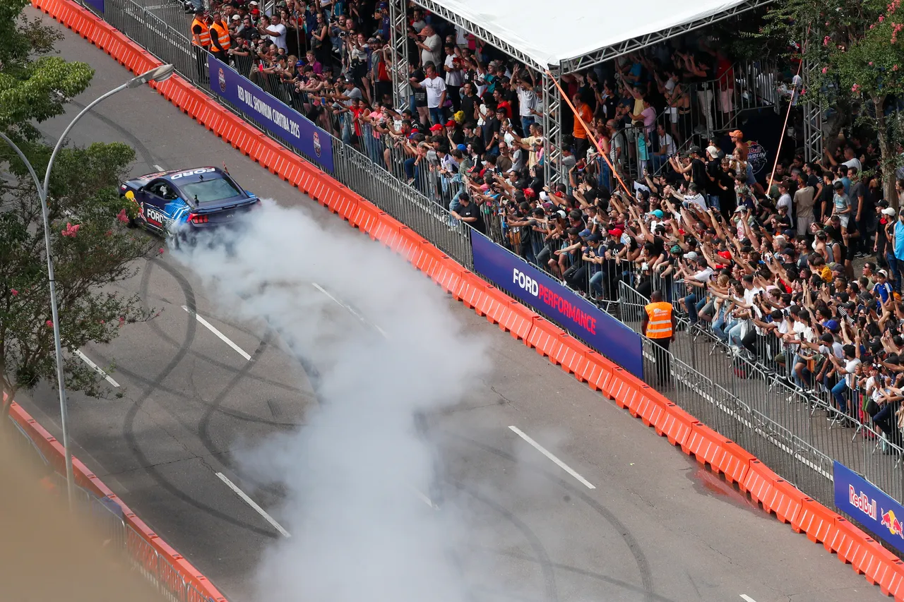 Imagem mostra carro fazendo manobras na avenida Cândidto de Abreu e centenas de pessoas em uma arquibancada assistindo