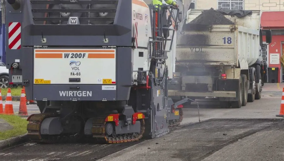 Imagem mostra máquinas trabalhando no asfalto de uma rua em Curitiba
