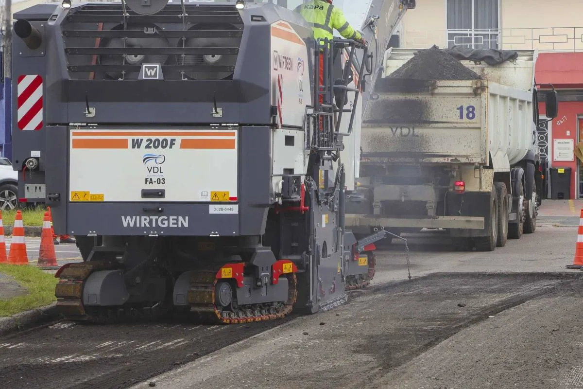 Imagem mostra máquinas trabalhando no asfalto de uma rua em Curitiba