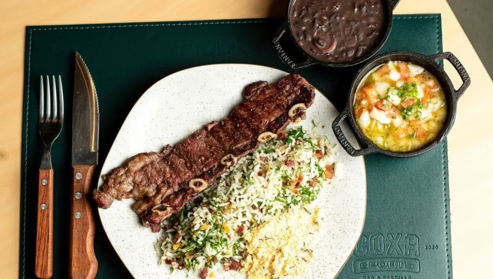 Assado de tira, acompanhando de arroz e farofa, uma cumbuca de feijão e outra de vinagrete