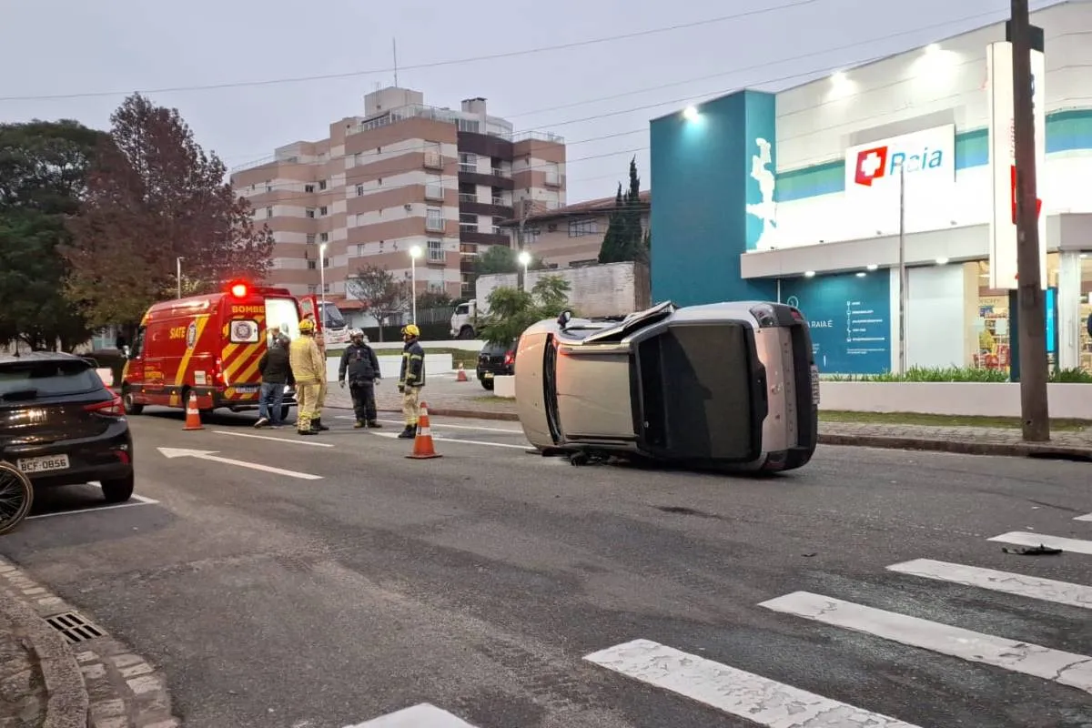Imagem mostra uma caminhonete tombada em uma rua de Curitiba