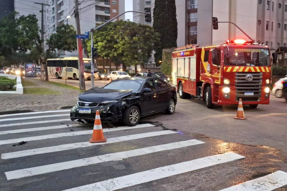 Imagem mostra um carro preto e um caminhão dos bombeiros em uma rua de Curitiba
