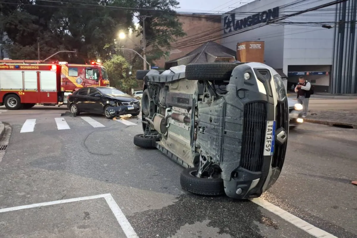 Imagem mostra uma caminhonete tombada em uma rua de Curitiba
