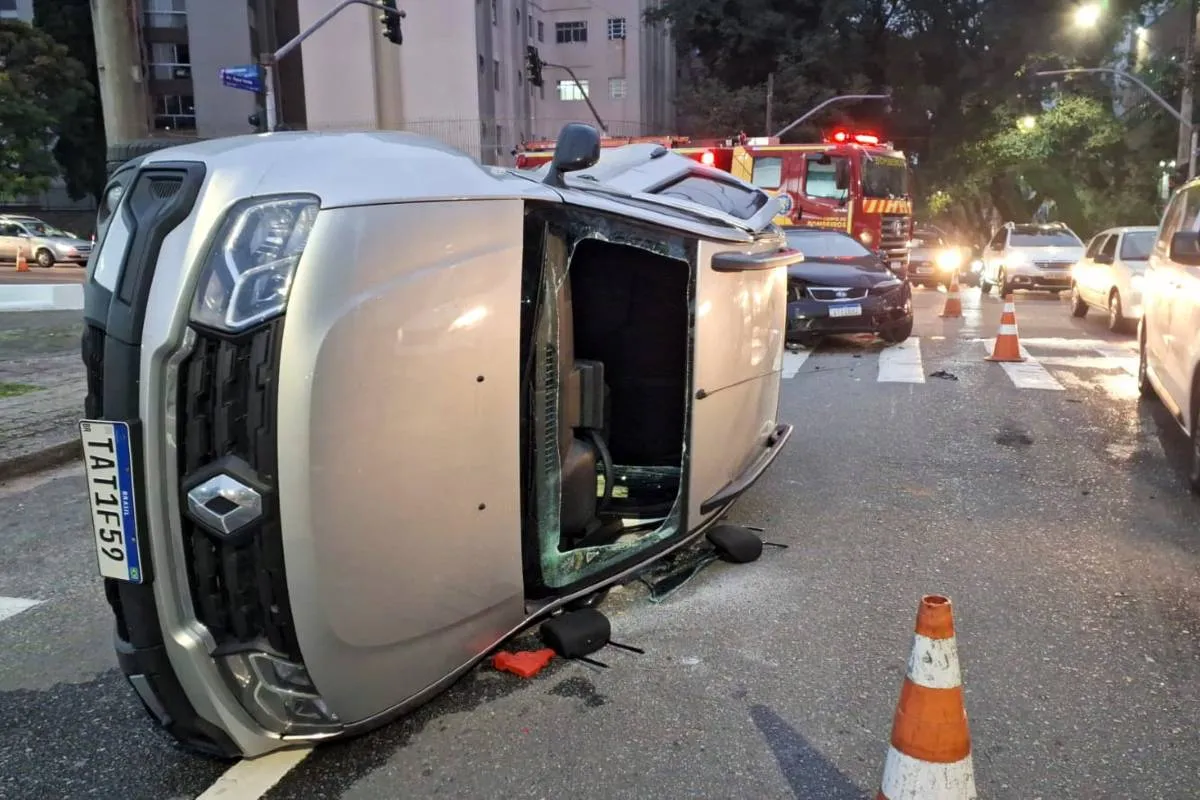 Imagem mostra uma caminhonete tombada em uma rua de Curitiba