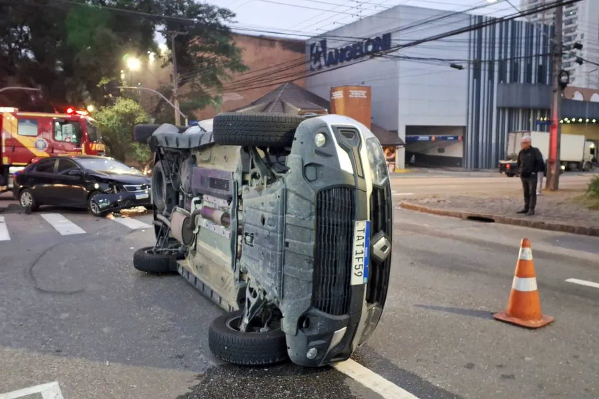 Imagem mostra uma caminhonete tombada em uma rua de Curitiba