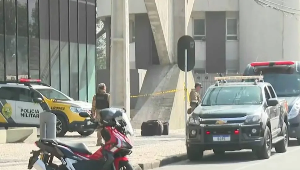 Imagem mostra viaturas em frente a um prédio com ameaça de bomba