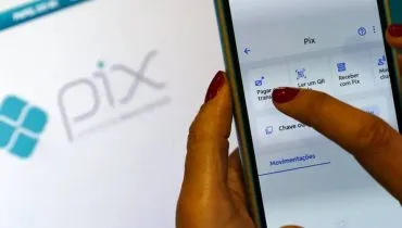 Imagem mostra uma tela de Pix com um celular na frente.