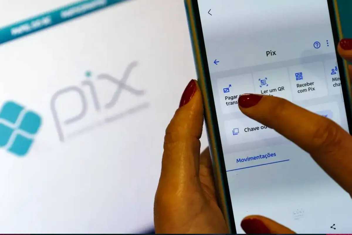 Imagem mostra uma tela de Pix com um celular na frente.