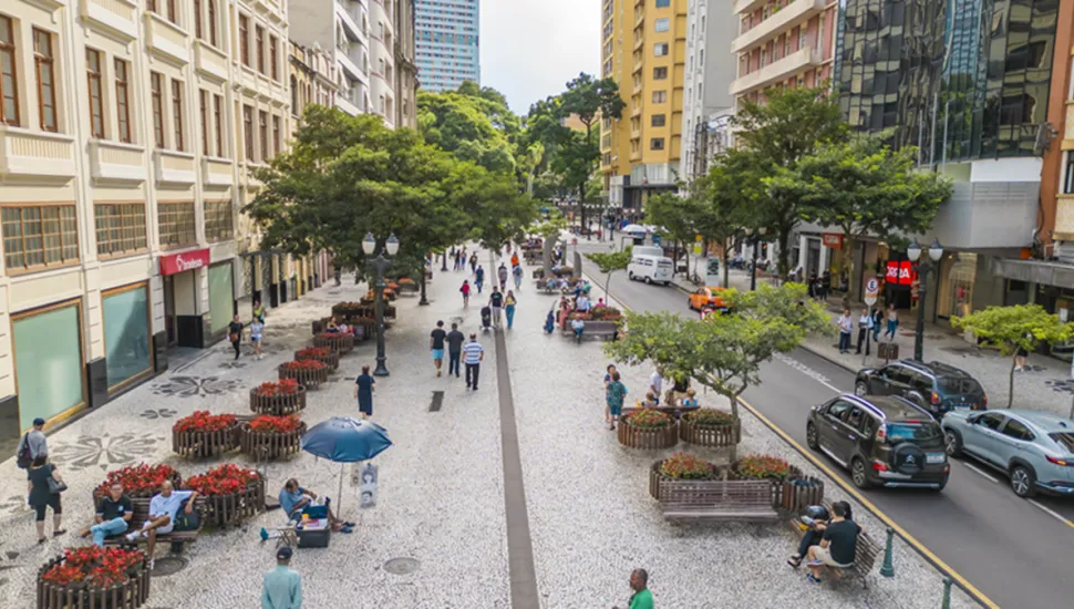 Imagem mostra pessoas caminhando no Centro de Curitiba