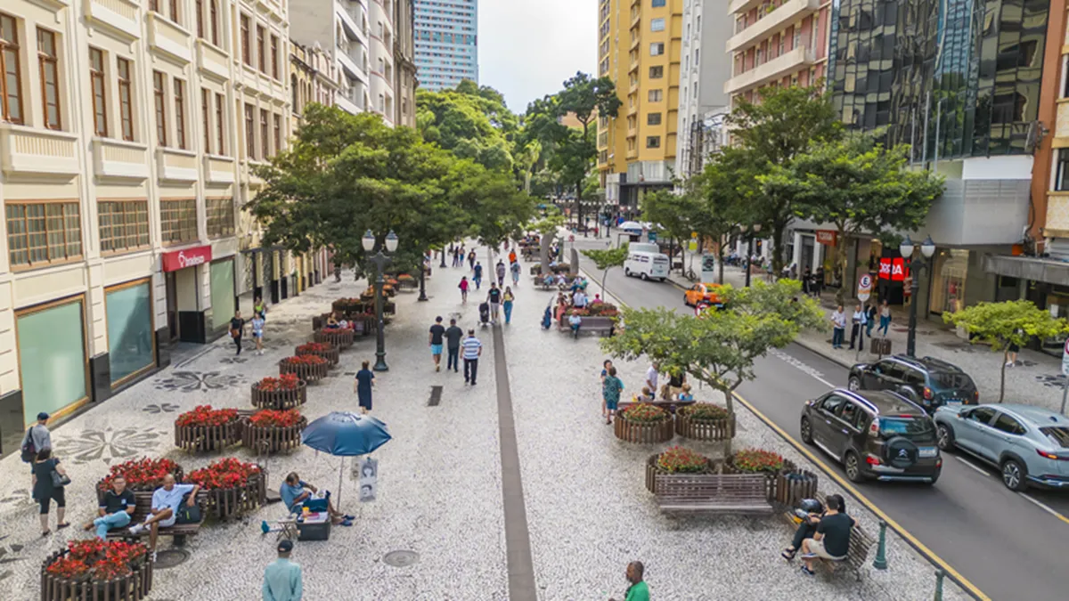 Imagem mostra pessoas caminhando no Centro de Curitiba