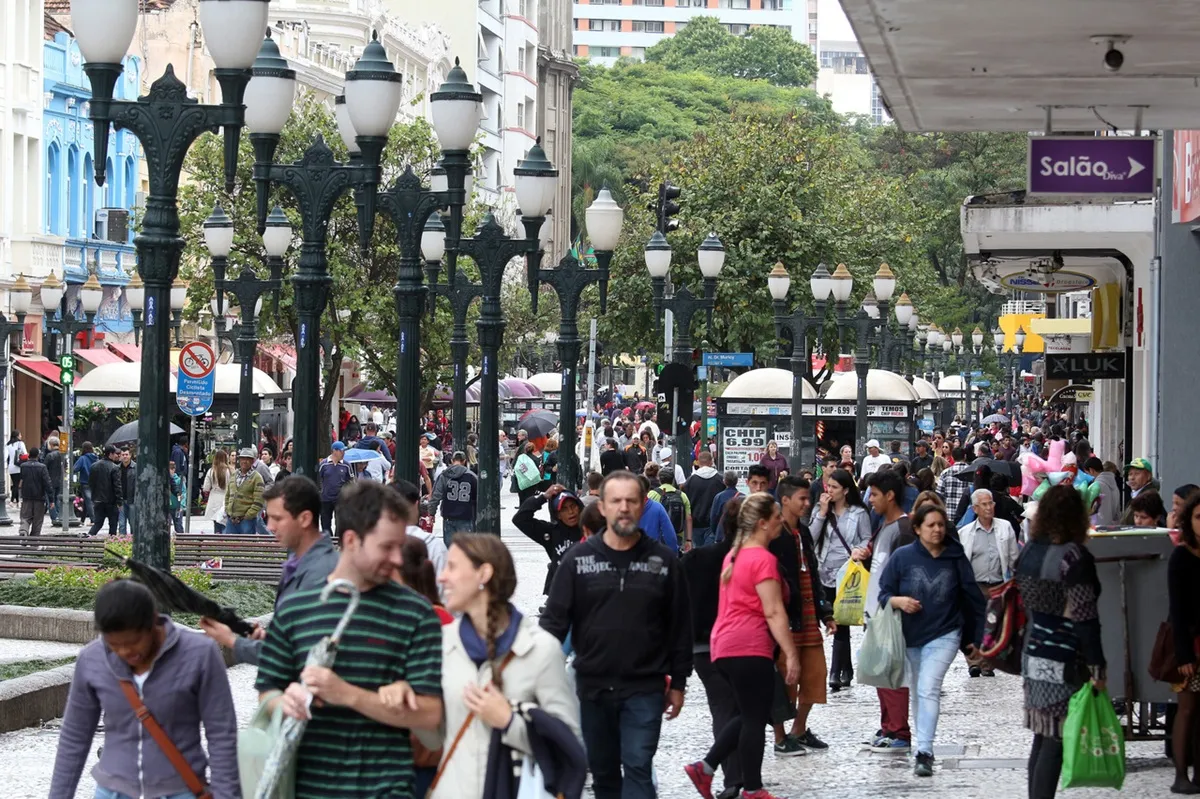 Imagem mostra pessoas andando no Centro de Curitiba. Movimento intenso no Centro de Curitiba