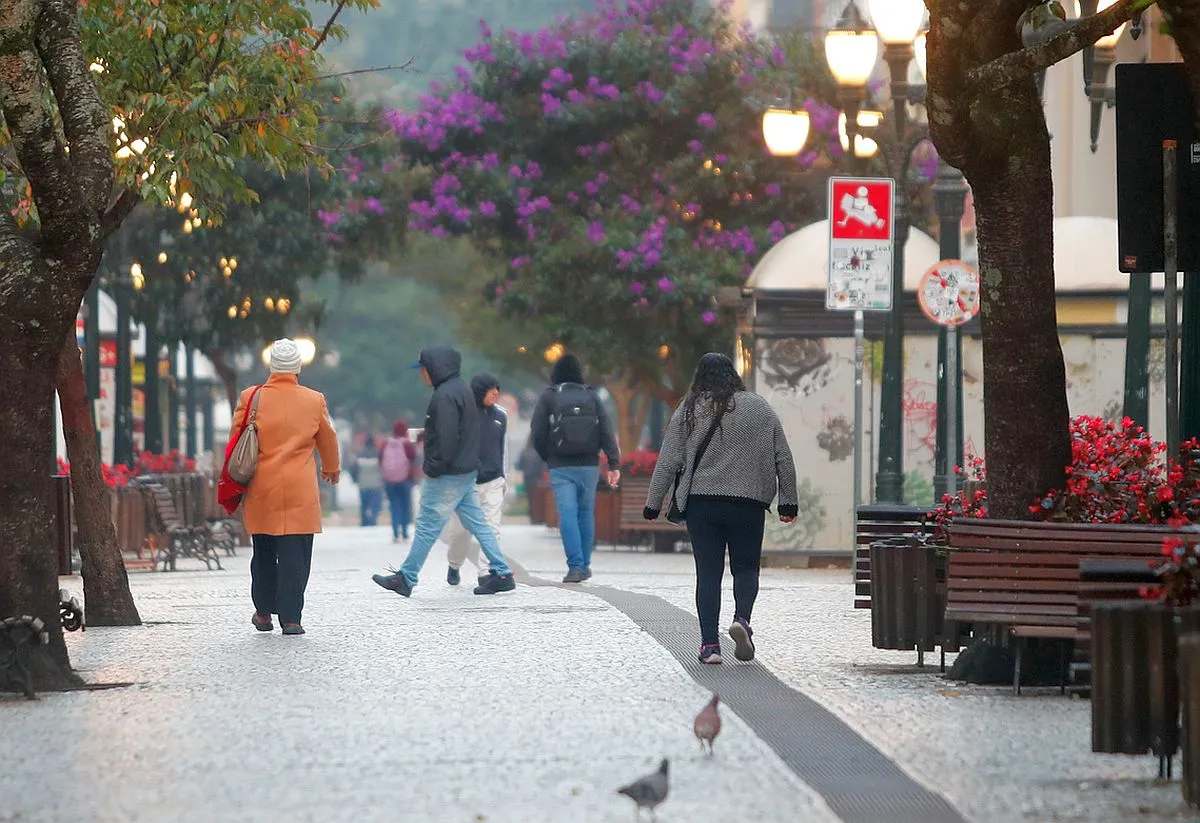 Imagem mostra o calçadão da Ruz Xv, em Curitiba, com várias pessoas caminhando agasalhadas
