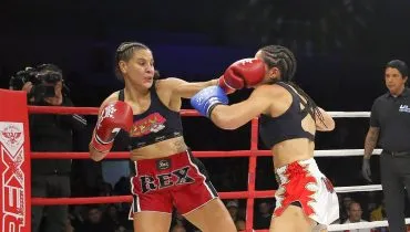 na imagem duas lutadoras trocam socos dentro de um ringue