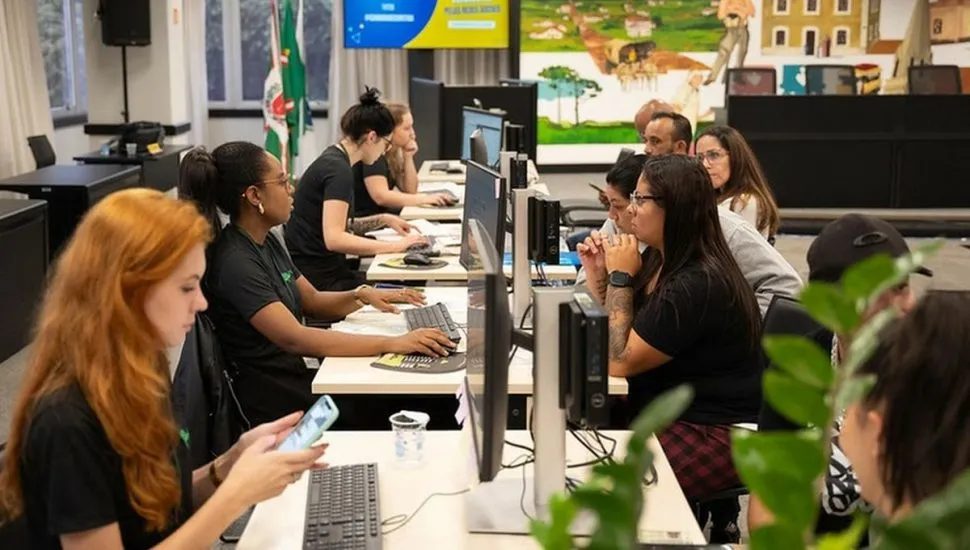 Na foto, dentro da Câmara, uma mesa grande com funcionários de um lado e a população de outro. Computadores no meio, entre eles