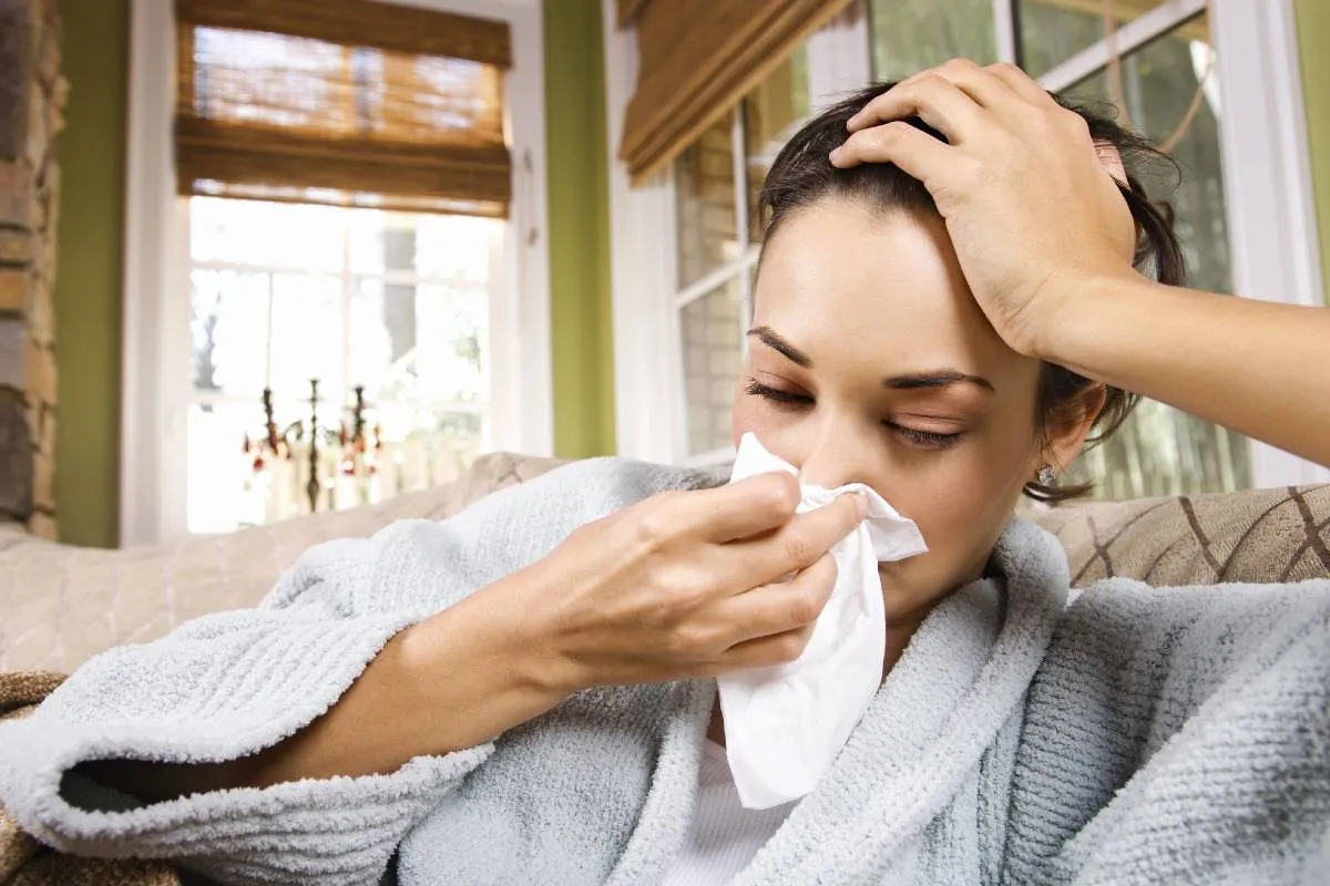 Imagem mostra uma mulher com gripe.