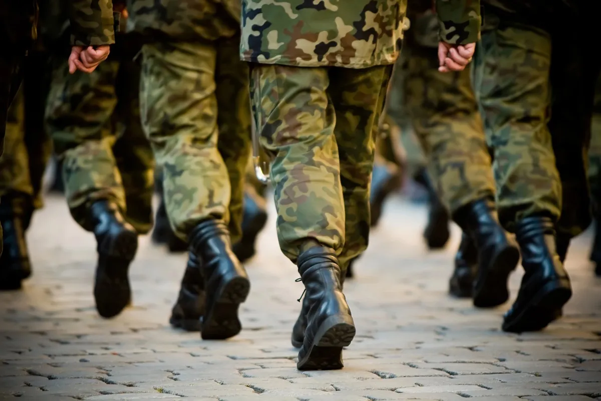 Imagem mostra pessoas com roupas e botas militares