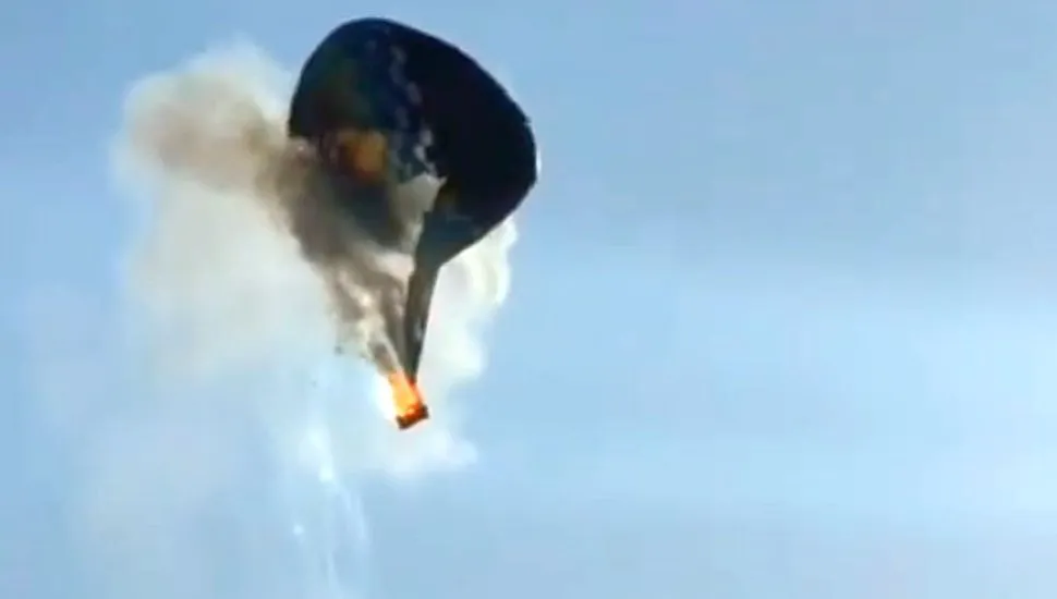 Imagem mostra balão em chamas e de despedaçando no ar durante queda livre.