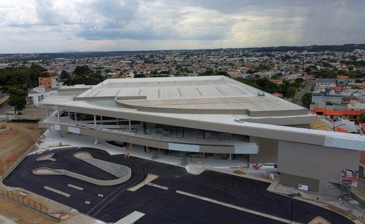 imagem é aérea, mostra toda a construção do shopping, e o bairro do Uberaba ao fundo