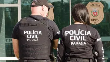 Imagem mostra dois policiais civis de costas com a logo da corporação.