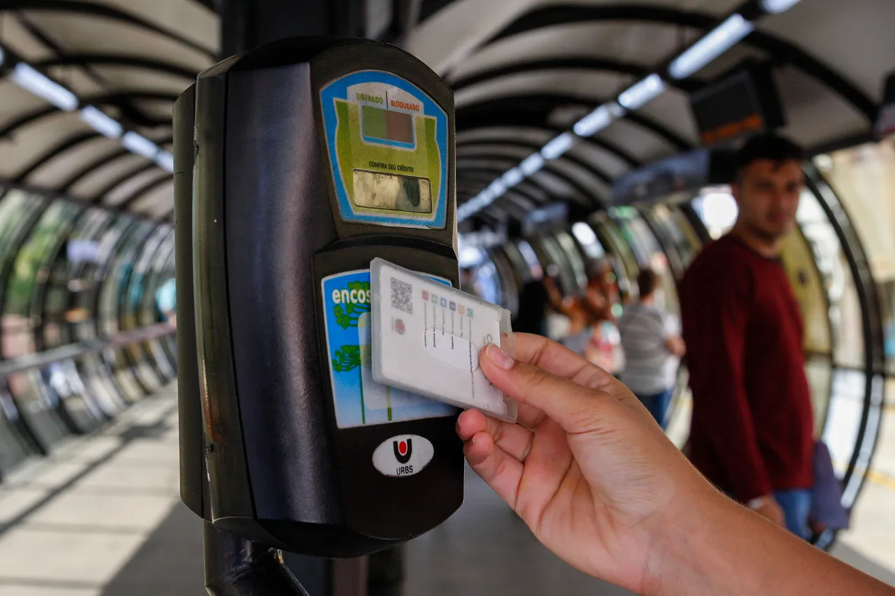 Imagem mostra usuário do transporte público passando o cartão transporte na catraca
