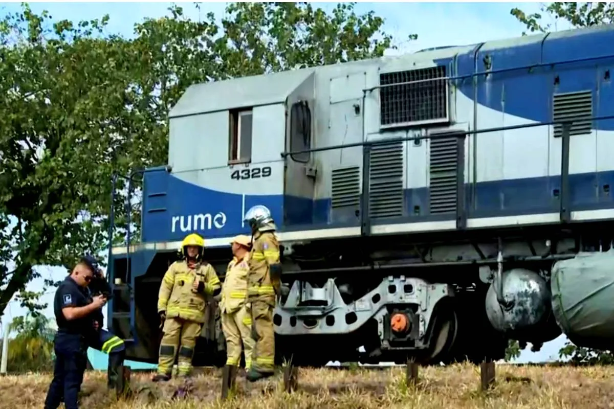 Imagem mostra a frente de um trem com bombeiros e policiais ao lado.