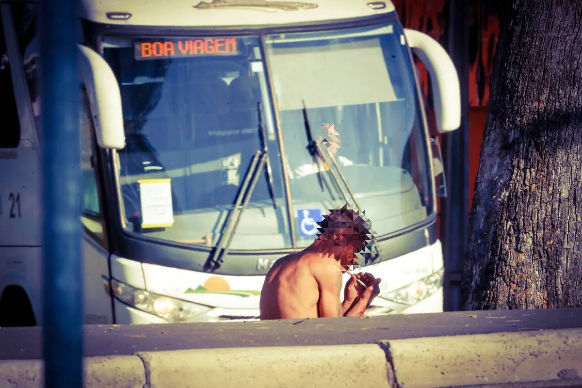 Imagem mostra um homem usando drogas em ao fundo, um ônibus com a mensagem: boa viagem.