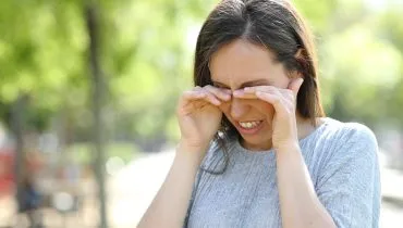 Imagem mostra mulher coçando os olhos