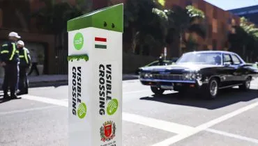 Imagem mostra agente de trânsito atravessando a rua, com novo eqipamento em forma de totem no primeiro plano