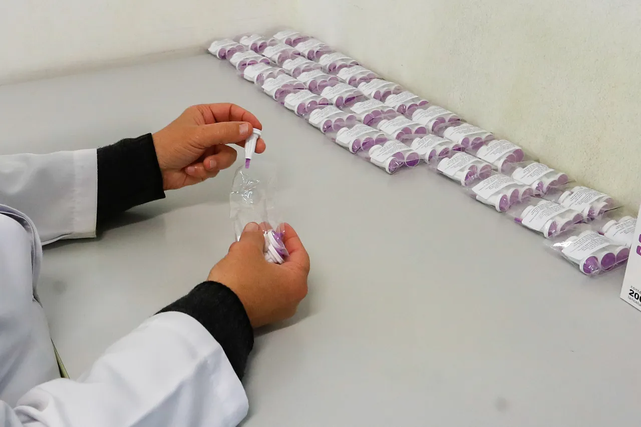 foto mostra duas mãos de uma laboratorista com amostras de sangue para o teste do pezinho