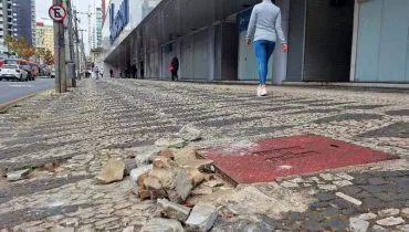 Imagem mostra uma calçada destruída em Curitiba.