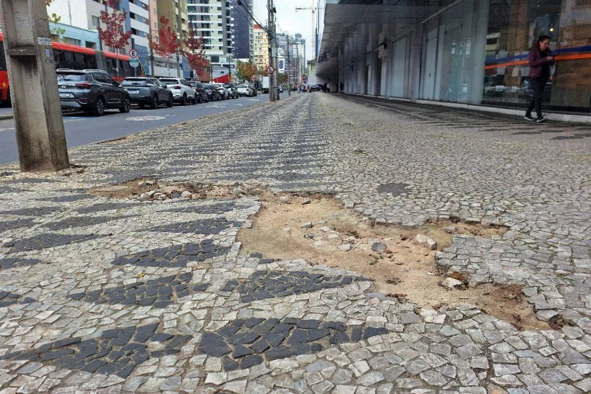 Imagem mostra uma calçada destruída em Curitiba.
