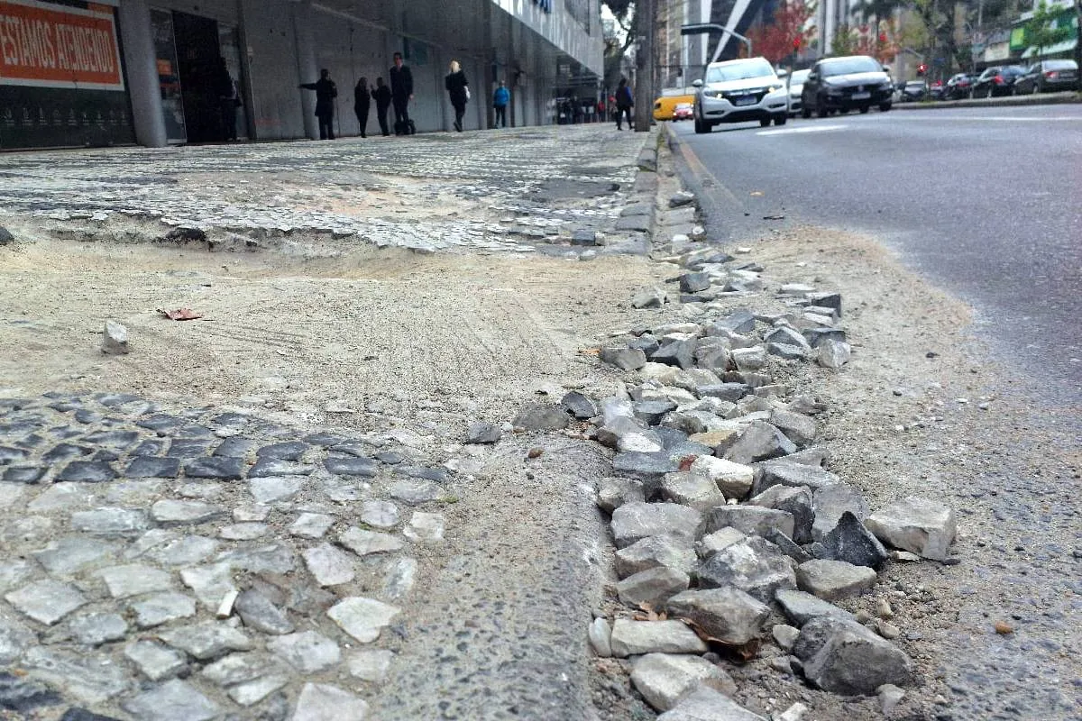 Imagem mostra uma calçada destruída em Curitiba.