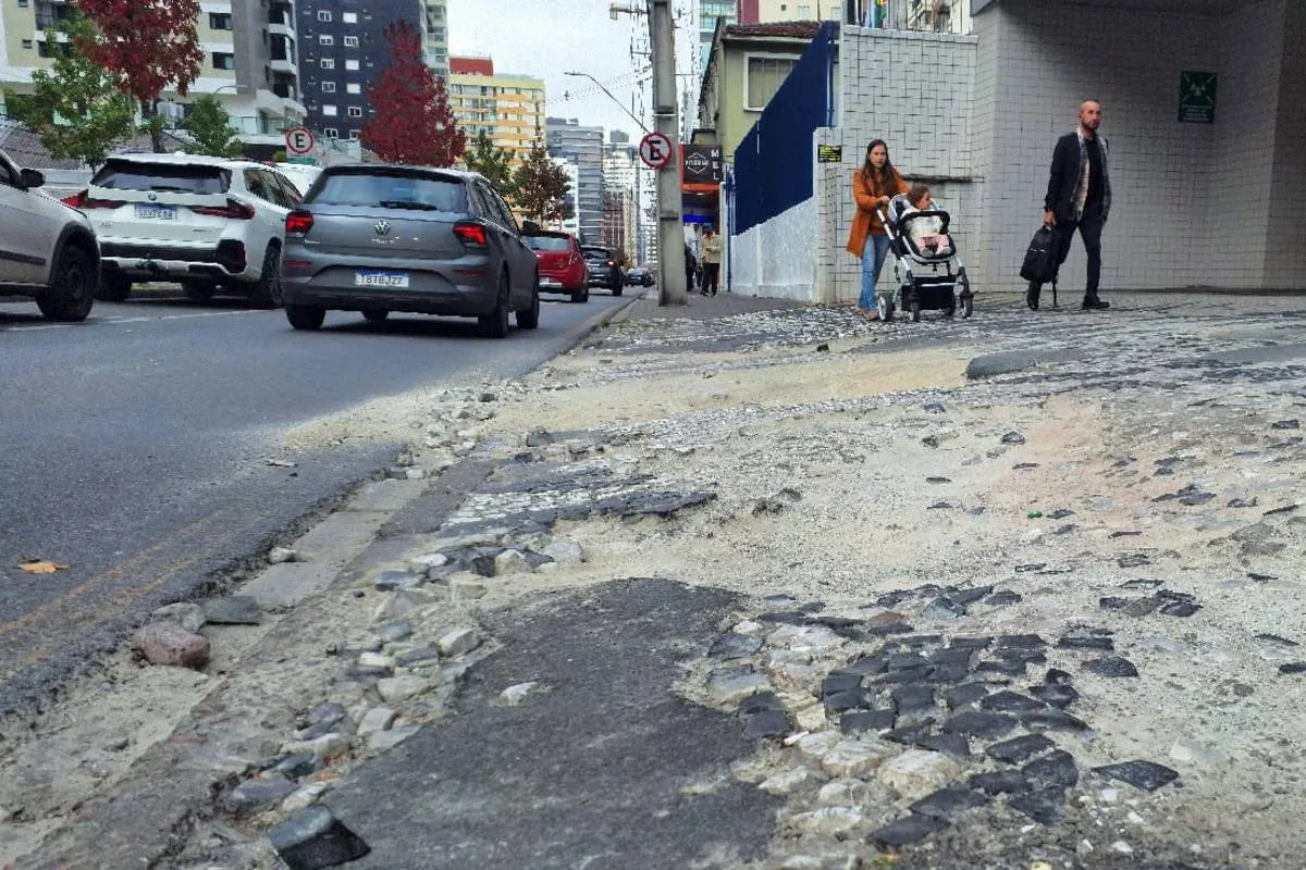 Imagem mostra uma calçada destruída em Curitiba.