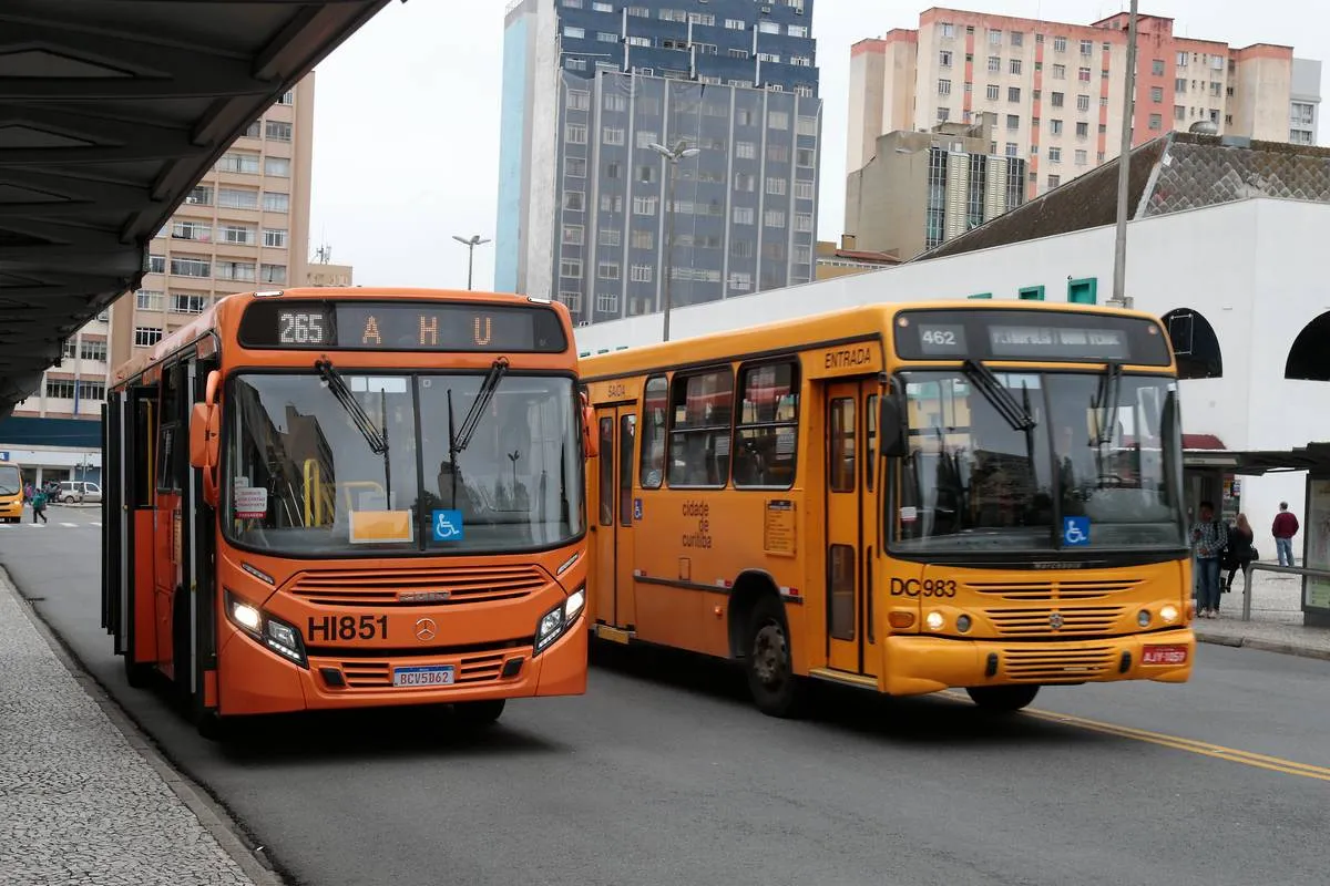 Imagem mostra dois ônibus estacionados em uma praça de Curitiba
