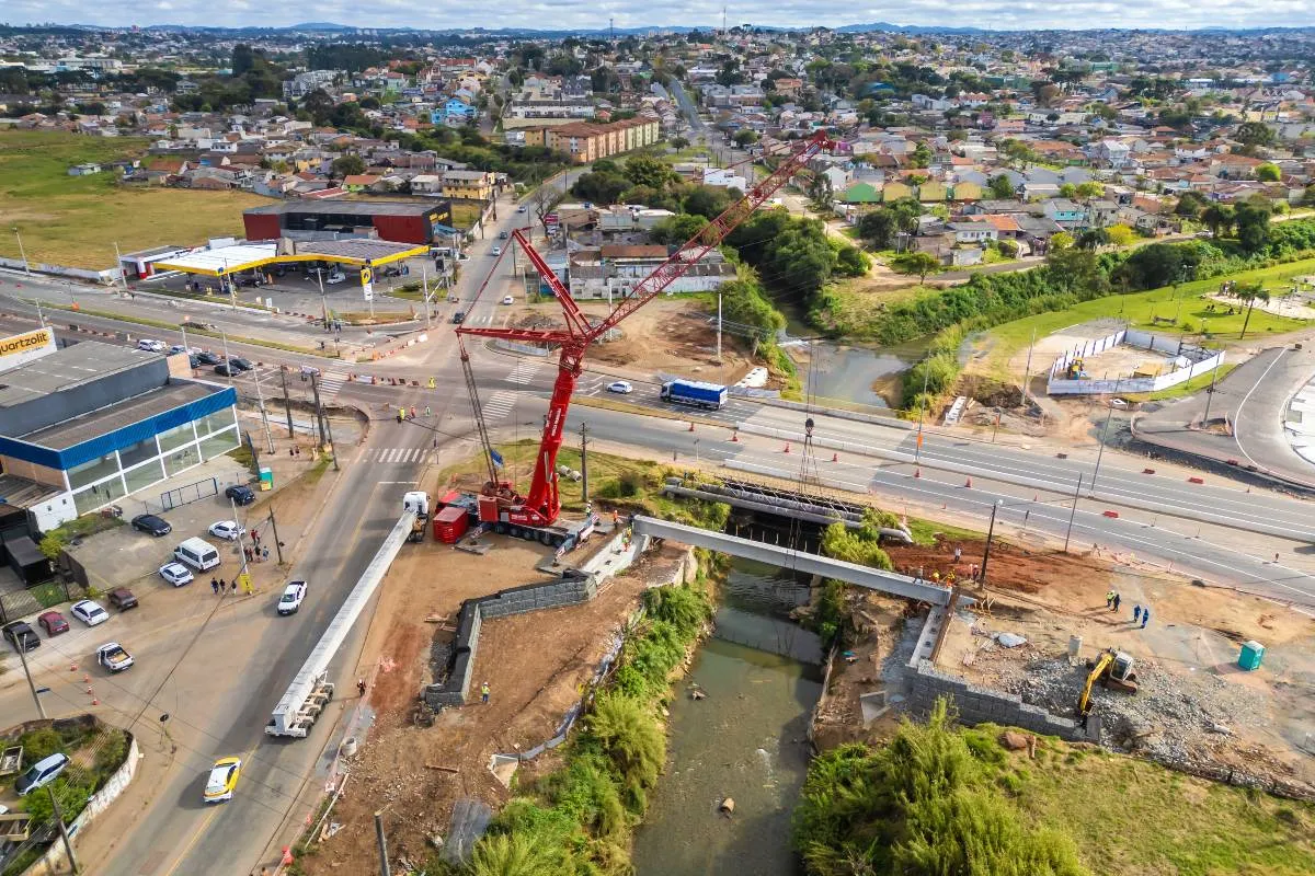 mostra o andamento da construção de uma nova ponte entre Curitiba e Pinhais.
